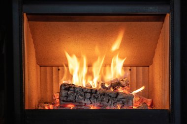 Ateş alevleri, yanan odun odunları, enerji sobası şöminesi, yakın çekim, ön görüş. Kışın sıcak bir yuva