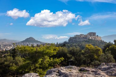 Atina, Yunanistan. Akropolis Kutsal Kayası 'ndaki Parthenon Tapınağı, Philopappos Tepesi' ndeki antik Yunan uygarlığı anıtı. Doğa, gökyüzü arkaplanı.