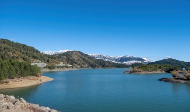 Yunanistan, Aoos Springs Gölü, Epirus. Metsovo köyü yakınlarındaki yapay göl hava aracı görüntüsü. Karlı Pindus dağ arkaplanı.