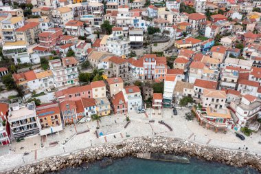 Parga, Yunanistan. Geleneksel İyon sahil şehrinin kayalık tepedeki renkli cephe binalarının hava aracı görüntüsü bulutlu gökyüzü