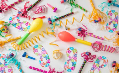 Carnival party supply. Serpentine, maraca, mask on white background. Invitation card, festive decoration, celebration event. Overhead view.