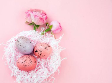 Paskalya yumurtası yuvası ve düğün çiçeği buketi pastel pembe arka planda, kopyalama alanı. Mutlu Paskalyalar