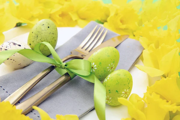 复活节餐桌摆设 黄色春花和彩蛋装饰 餐巾和白盘上的金色餐具 — 图库照片
