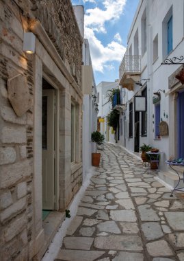 Greece. Tinos island of art, Cycladic architecture at Pyrgos village paved street, whitewashed wall, stair, sunny day. clipart