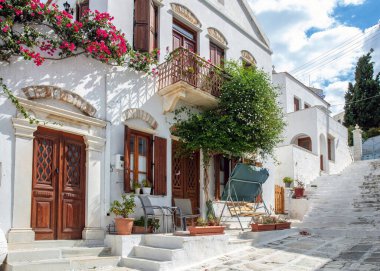 Yunanistan. Tinos sanat adası, Pyrgos köyünün asfalt sokağındaki Cycladic mimarisi, beyazlatılmış duvar, merdiven, güneşli gün..
