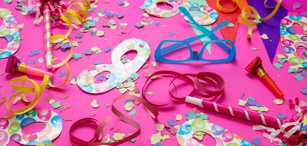 Carnival birthday party. Confetti and serpentines on bright pink background. Holiday celebration and decoration