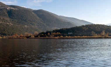 Yunanistan, Pamvotis Gölü, Ioannina şehri, Epirus. Giannena, karanlık sakin su manzarası, nisaki, doğa, öğleden sonra mavi gökyüzü arkaplanı..