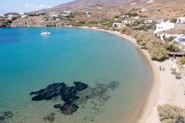 Tinos Adası, Cyclades Yunanistan. Agios Romanos köyünün hava aracı görüntüsü, şeffaf sakin deniz, kumlu sahil, demirli yat. Yaz hedefi