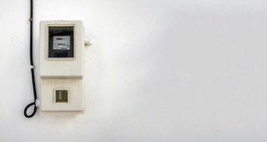 Yunanistan 'ın Cyclades adasındaki boş duvar zemininde eski bir açık hava elektrik sayacı. Kilovat saat ölçümü. Boşluğu kopyala