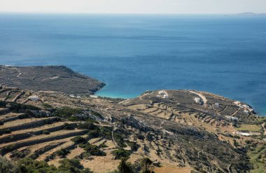 Kiklad adası turizm beldesi Yunanistan 'ın hava aracı görüntüsü. Rocky manzarası, beyazlatılmış bina, uçsuz bucaksız mavi durgun Ege deniz suyu arka planı.