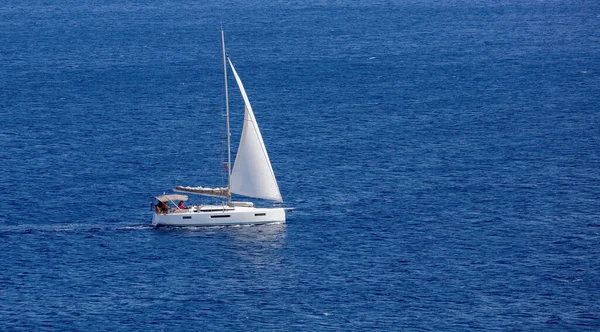 波打つ広大な青いエーゲ海の水の背景の真ん中に乗組員と白い帆と帆船 ギリシャ キクラデス諸島での夏の休暇 — ストック写真