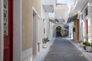 Andros Adası, Chora kasabası, Cyclades 'in varış noktası Yunanistan. Geleneksel hediyelik eşya dükkanına giden ev duvarları arasında dar bir ara sokak..