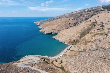 Andros Adası, Halkolimionas Sahili, Kiklades 'in varış noktası Yunanistan. Gözlerden uzak kayalık dağ ve sahil manzaralı, açık deniz suyu mavi gökyüzü.
