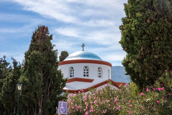 アンドロス島 コラ町 キクラデス諸島の目的地ギリシャ 白い正統派教会はアーチ型の窓の青いドーム 木を通して見る 空の背景 — ストック写真
