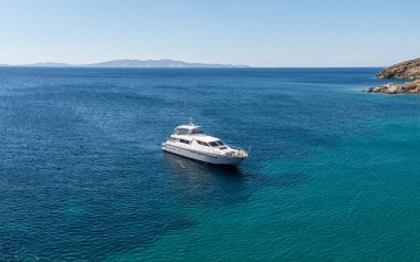 Yunanistan 'ın yaz mevsimi Kiklad adası. Dalgalı mavi turkuazlı demirli lüks yat derin Ege deniz suyu arka planı, güneşli bir gün.. 