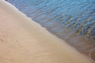 Kumsal boş, okyanus şeffaf dalgalı Ege deniz suyu ıslak kuma dokunuyor. Yunanistan yaz tatili, Cyclades Adası. Boşluk