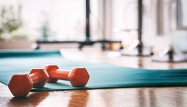 Yoga egzersiz minderinin üstündeki dambıllar yakın plan, beden eğitimi, egzersiz ve spor konsepti.