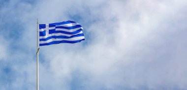 Yunanistan 'ın işareti. Rüzgarda dalgalanan bayrak direğinde Yunan ulusal bayrağı, mavi gökyüzü arka planı