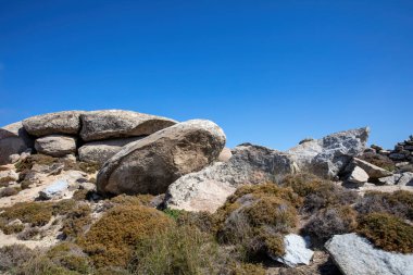 Büyük, pürüzsüz granit kayalıklı ay manzarası. Cyclades Yunanistan 'ın Tinos Adası' ndaki Volax köyü. Yaz güneşli bir gün, doğa, mavi gökyüzü arka plan.