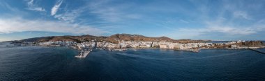 Tinos Adası Hora kasabası Cyclades Yunanistan. Hava aracı panoramik liman manzarası, demirli gemi, Ege engin denizi, mavi gökyüzü, yaz tatili. Pankart