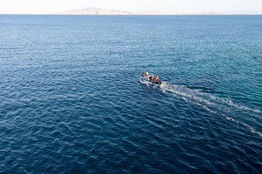 Sürat teknesi mavi dalgalı Ege açık deniz arka planında yelken açar. Macera, rahatlama. Tinos Adası Kiklad 'ı, insanlar Yunanistan' da yaz tatilinin tadını çıkarıyor.