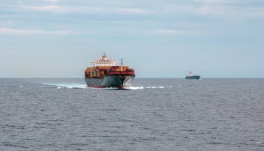 Dalgalı denizle dolu konteynır kargo gemisi limana ulaştı. Ticari ihracat ve lojistik, su taşımacılığı, ticari ticaret.