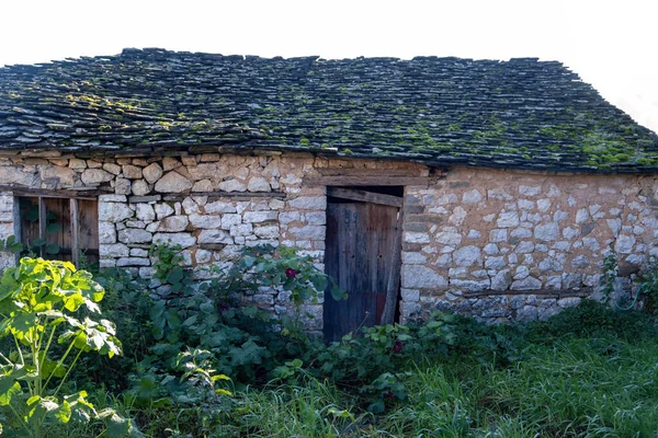 Opuszczony Stary Kamienny Budynek Zamkniętymi Drzwiami Drewnianymi Dachem Kamienia Okiennego — Zdjęcie stockowe