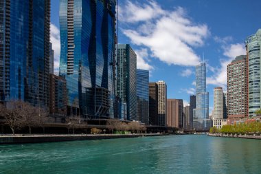 Chicago şehir manzaralı ABD. Chicago şehri rıhtım manzaralı modern cam bina nehir kanalında, dalgalı su, mavi bulutlu gökyüzü arka planı.