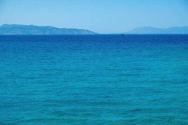 Gemi, açık mavi Yunan arka planının altında geniş Akdeniz 'de yelken açıyor. Dalgalı okyanus suyu yüzeyi, yaz mevsimi, uzay.