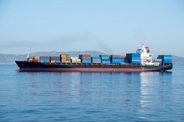 Konteyner kargo gemisi Pire Limanı Yunanistan 'dan ayrılıyor. İthalat ve ihracat için ağır malların depolanması ve taşınması. Akdeniz 'deki yansıma.