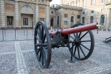 Savaş karşıtı konsept. Gamla Stan Stockholm İsveç 'teki Royal Palace' ın asfalt bahçesinde İsveç bayrağıyla kaplanmış eski bir metal top..