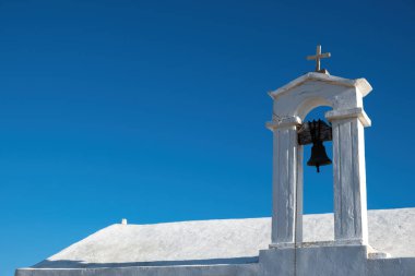 Kilise çanı, açık mavi arka planda beyaz renkli ortodoks şapel çatısı, Gavdos adası, dini varış noktası Girit, Yunanistan. Boşluğu kopyala