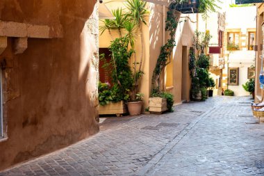 Geleneksel taş duvar binası, dar, boş asfalt yolda saksı bitkisi yaz tatili, güneşli bir gün. Chania Old Town, Girit Adası, Yunanistan.