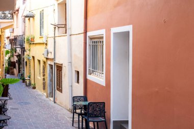Girit adası Yunanistan 'daki Chania Old Town' da geleneksel bir kafe. Boş sandalye masası, saksı çiçeği, asfalt sokak, yaz günü..
