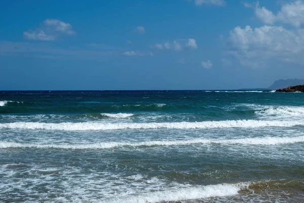 stock image Greek ripple dark sea water, splashing white foam, blue sky background, copy space. Summer vacation destination Greece. Ad template