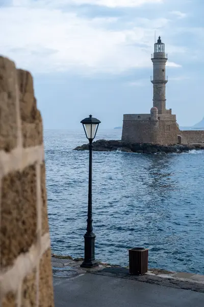 Yunanistan 'ın başkenti Chania Girit' in Venedik limanındaki deniz feneri. Karanlık deniz suyu, bulutlu gökyüzü arkaplanı. Firkas Kalesi 'nden görüntü. Dikey