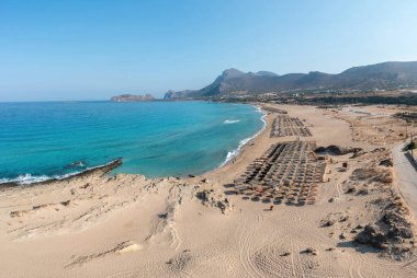 Phalasarna kumlu plajı, Girit adası Yunanistan. Uçsuz bucaksız dalgalı deniz suyunun insansız hava aracı görüntüsü berrak mavi gökyüzü ile buluşur. Yaz tatili için ünlü bir tatil yeri..