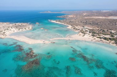 Elafonisi lagünü, Girit adası Yunanistan. Turkuaz şeffaf deniz suyu, kayalık oluşum, mavi gökyüzü, pembe kumlu sahil..