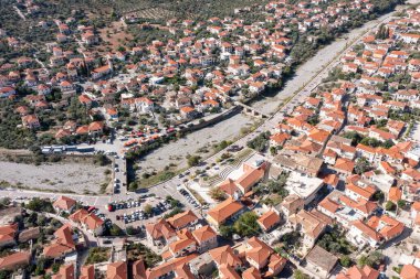 Leonidio, Arcadia, Moreloponnese, Yunanistan. Geleneksel binası, kuru Dafnon nehir yatağı ve köprüsü olan tarım kasabasının insansız hava aracı manzarası.