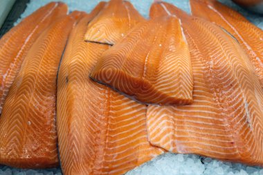 Açık hava piyasası arka planında buzlu taze çiğ somon filetosu. Turuncu renkli balık, sağlıklı deniz ürünleri, omega3, suşi, saşimi..