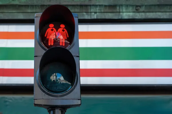 Red traffic light with replaced the figure with homosexual couple. Two same-sex girl holding each other hand at stoplight. LGBT, LGBTQ friendly city. Space