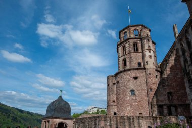 Almanya, Schloss Heidelberg kalesinin üst kısmı bayrak, saray ve gözetleme kulesi, Alman doğası ve mavi gökyüzü arka planıyla. 