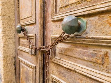 Eski, yıpranmış ahşap kapı arka planında paslı asma kilit ve zincir var. Manzarayı kapat. Terk edilmiş ev.