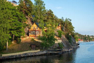 Stockholm İsveç 'teki Sandhamn, Archipelago' daki eski geleneksel villa. Deniz suyundaki kır evi yansıması, gezi teknesinden doğa manzarası..