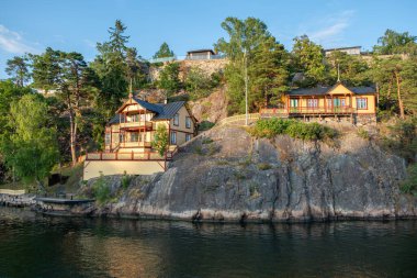 Stockholm İsveç 'teki Sandhamn, Archipelago' da geleneksel lüks villa. Deniz suyundaki kır evi yansıması, gezi teknesinden doğa manzarası..