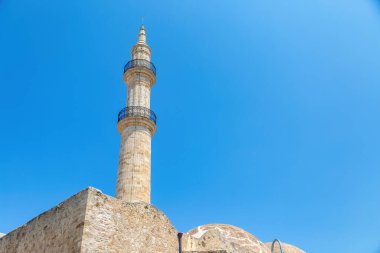 Yunanistan 'ın Girit adasındaki Rethymno şehrindeki Neratze Camii sembolik minare kulesi. Mavi gökyüzü arkaplanındaki İslami anıtın üst kısmı.