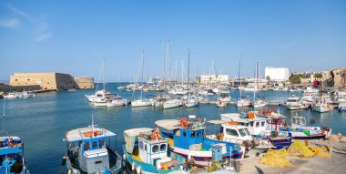 Girit adası, Yunanistan. Heraklion 'a demir atmış gemi ve gemi. Eski Venedik limanı, sakin deniz suyu, mavi gökyüzü arka planı..