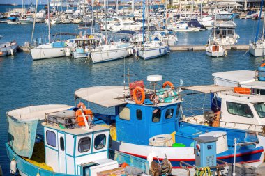 Girit adası, Yunanistan. Direkli ve balıkçı teknesi Heraklion 'da eski Venedik limanında, sakin deniz suyu, mavi gökyüzü arka planı.