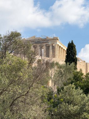 Atina, Yunanistan Arkeolojik İstikamet. Akropolis kayasındaki Parthenon Tapınağı 'nın arka planındaki bulutlu gökyüzü arkaplanının altına bak. Dikey