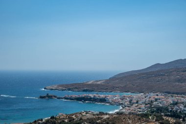 Andros Adası, Chora, Cyclades Yunanistan. Beyaz kasaba binaları, körfez ve pelerin manzarası, güneşli bir yaz günü.